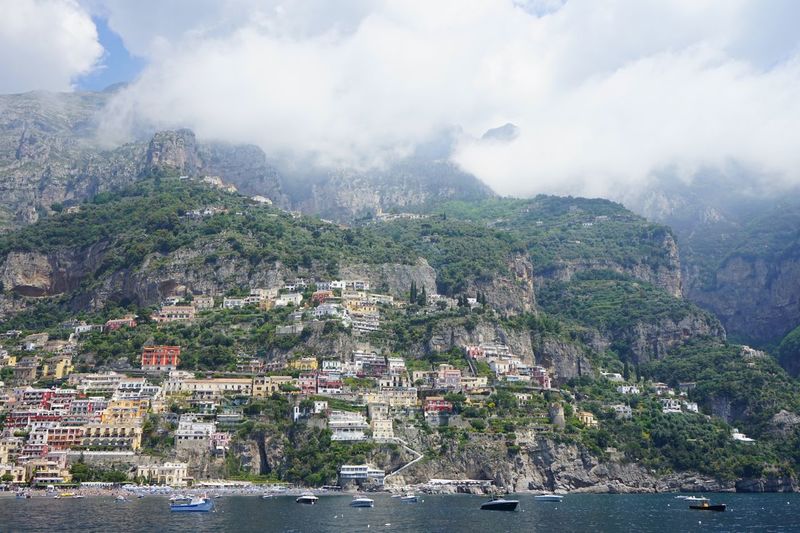 Aerial view of city by sea against sky