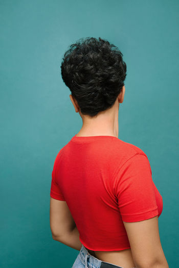 Rear view of teenage girl against blue background