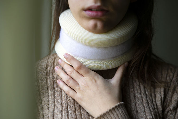 Young woman touching her cervical collar.
