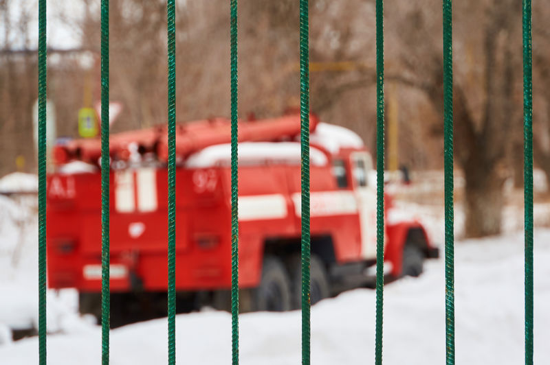 Truck seen through metallic gate during winter