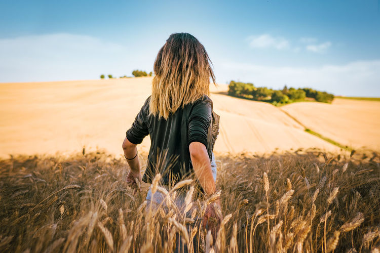 Rear view of woman in wheat field