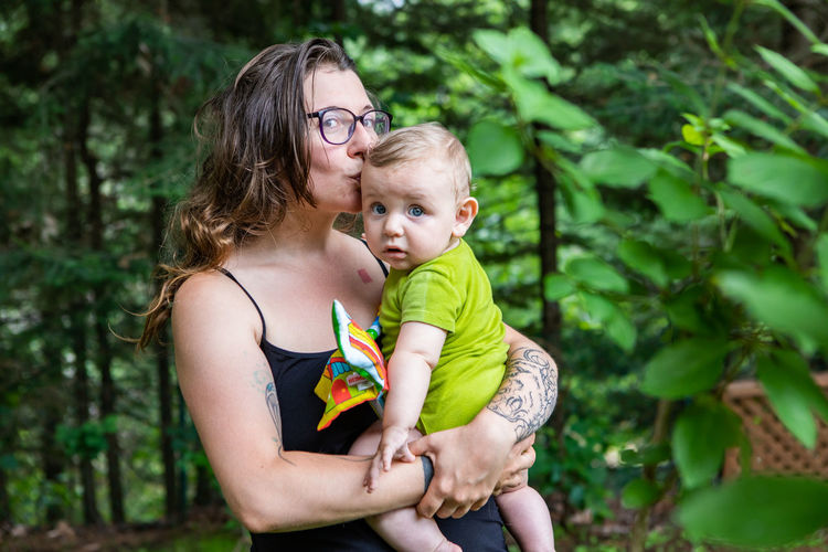 Portrait of mother kissing son outdoors