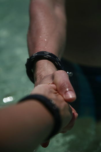 Cropped image of friends shaking hands in swimming pool