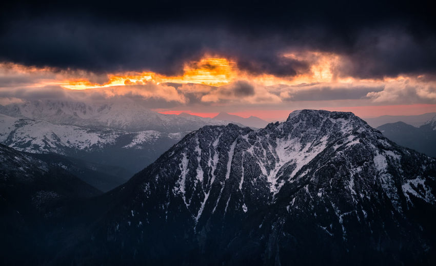 Scenic view of snowcapped mountains against sky during sunset