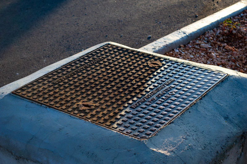 High angle view of metal grate on road