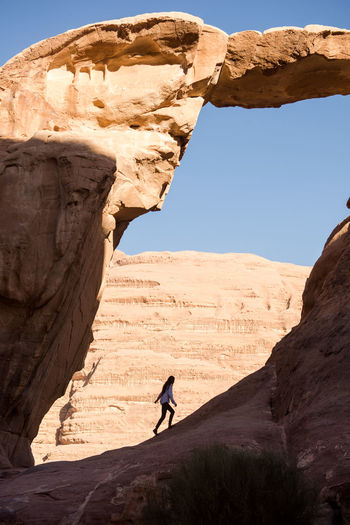 A female hiker explores a natural arch