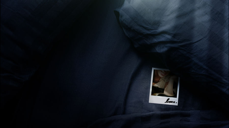 Polaroid under the pillow on the bed on a lonely day polaroid photos are impressive and seen secrets