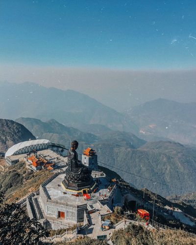 High angle view of buddha statue on mountain against sky