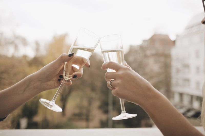 Cropped hands hand toasting champagne flutes