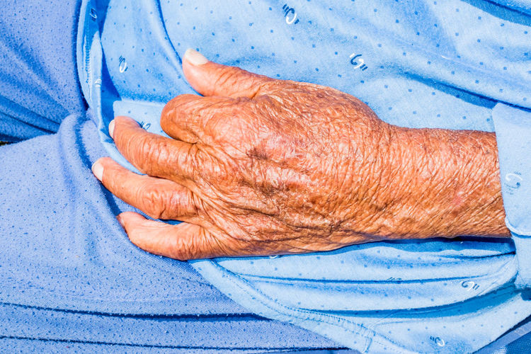 Close-up of woman hand on blue wall
