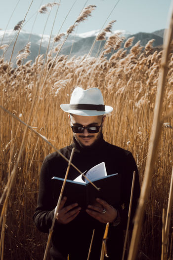 Young man wearing sunglasses standing on field