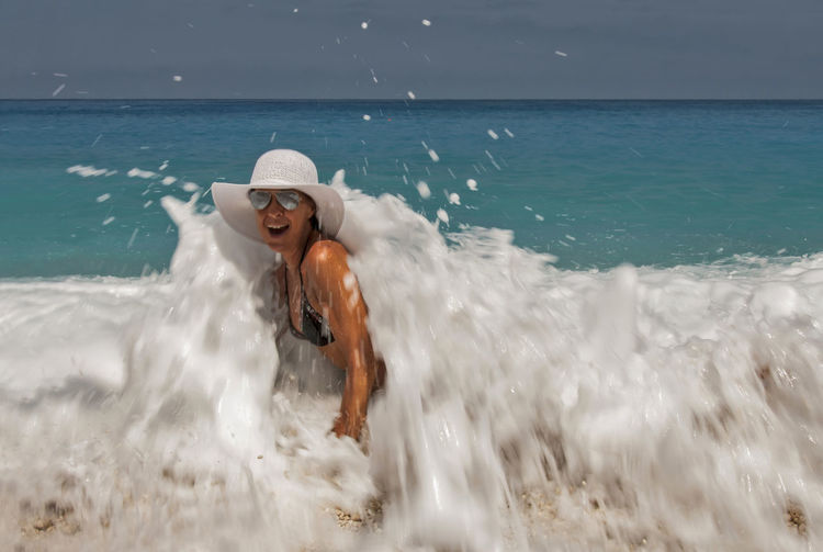 Waves splashing on woman in sea