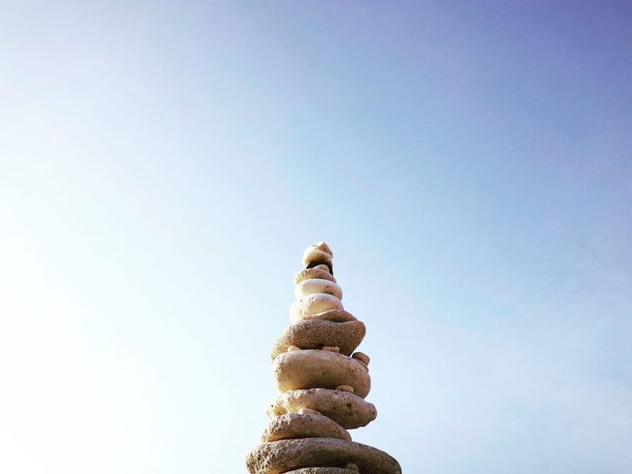 Low angle view of stones stacked against sky