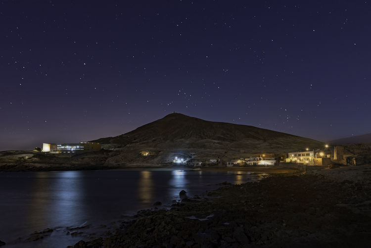 Scenic view of illuminated mountains against sky at night
