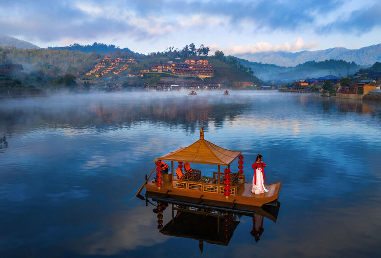 High angle view of woman standing on gondola in lake