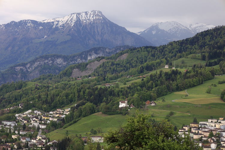Scenic view of mountains and houses against sky. mountains switzerland