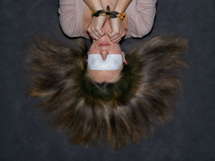 Directly above shot of blindfolded woman lying on floor
