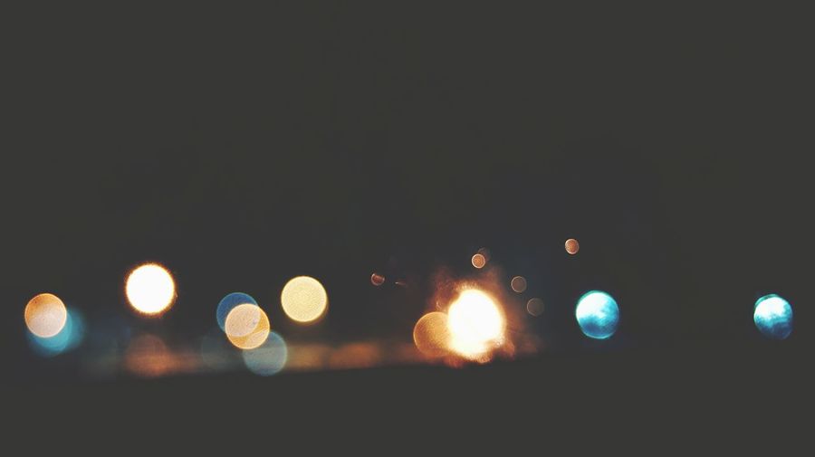 Close-up of illuminated lights against sky at night
