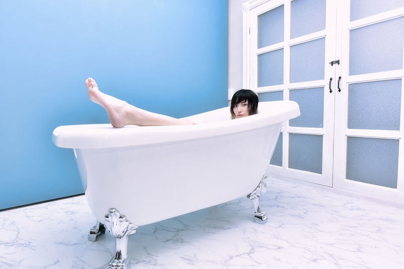 Young woman lying down in bathroom