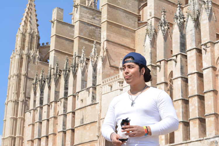 Low angle view of man standing against palma cathedral on sunny day