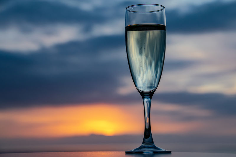 Glass of champagne overlooking a sunset sky