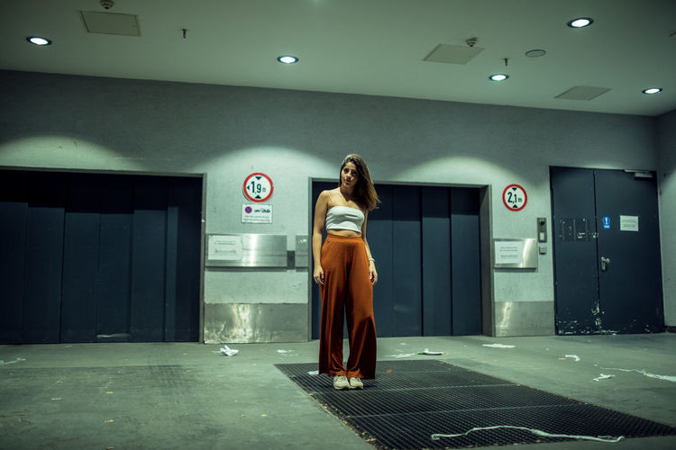 Full length of woman standing against elevator