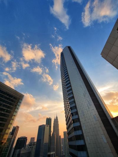 Low angle view of modern buildings against sky during sunset
