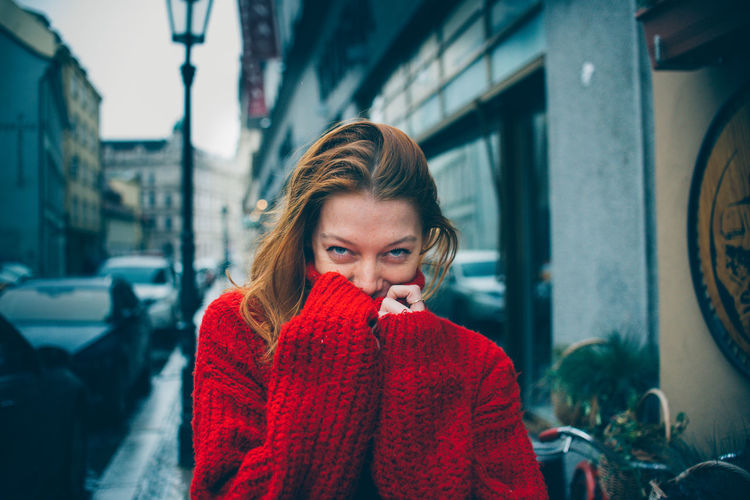 Portrait of young woman in city during winter
