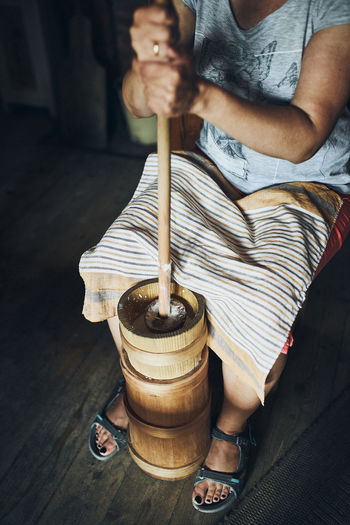 Woman making butter with butter churn. old traditional method making of butter