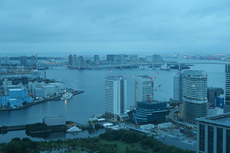 High angle view of city by sea against sky