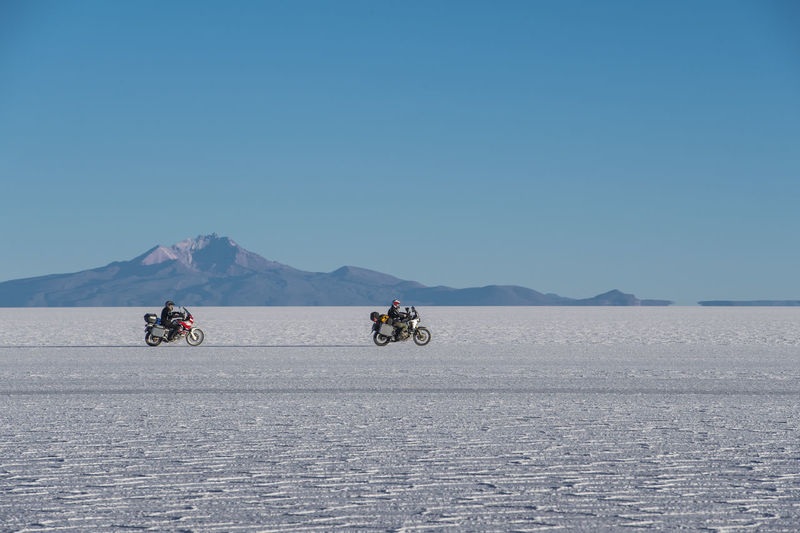Two men riding touring motorbike's on the salt flats of uyuni