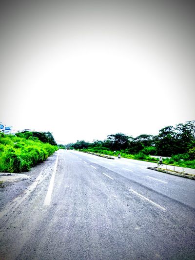 Road passing through landscape against clear sky