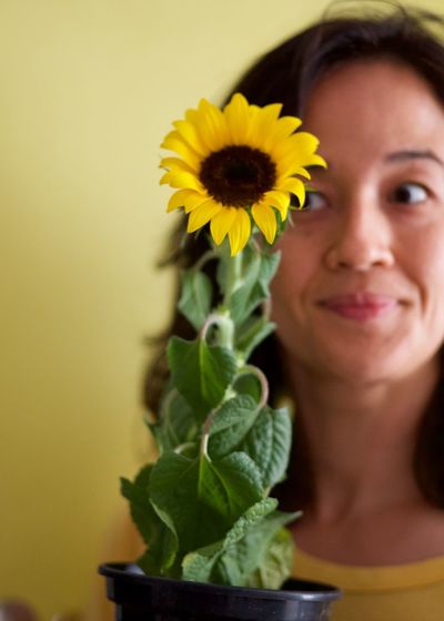 Portrait of smiling woman with yellow flower