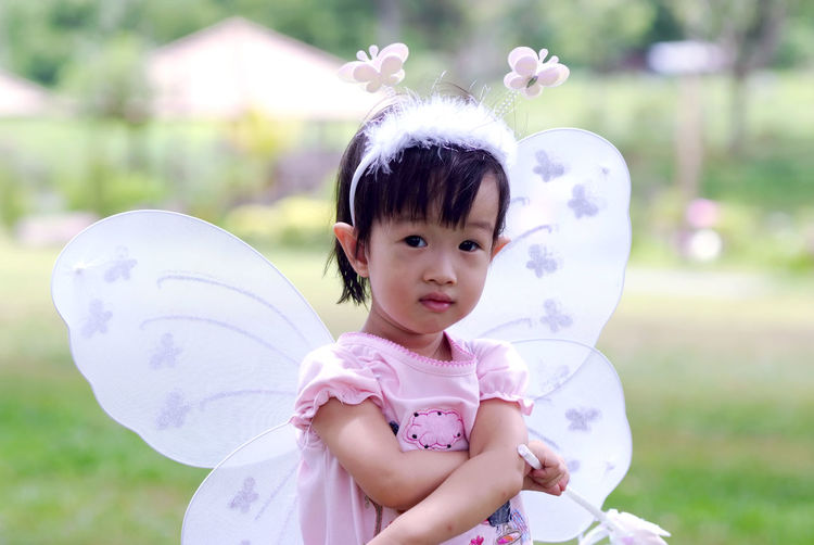 Close-up portrait of cute girl wearing angel costume