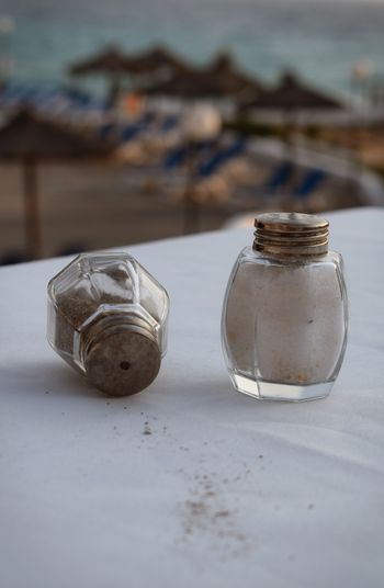 Close-up of salt and pepper shakers on table at sidewalk cafe