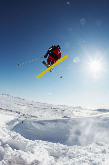 Skier jumping off snowy slope in iceland
