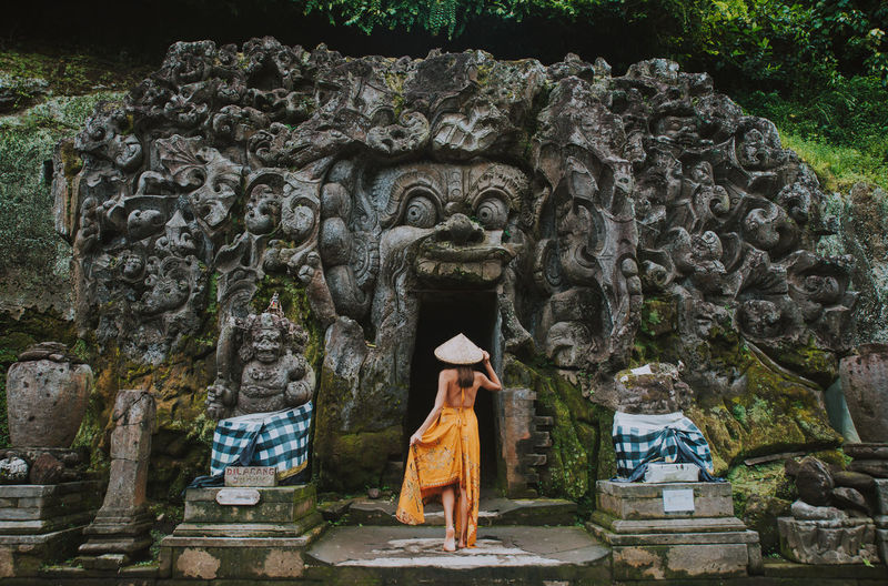 Rear view of woman walking at goa gajah