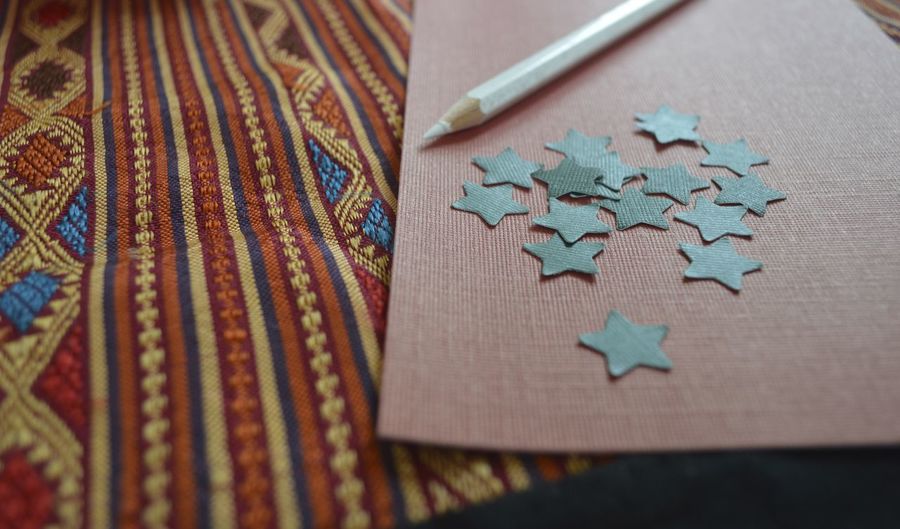 Close-up of star shape craft product by pencil on bed