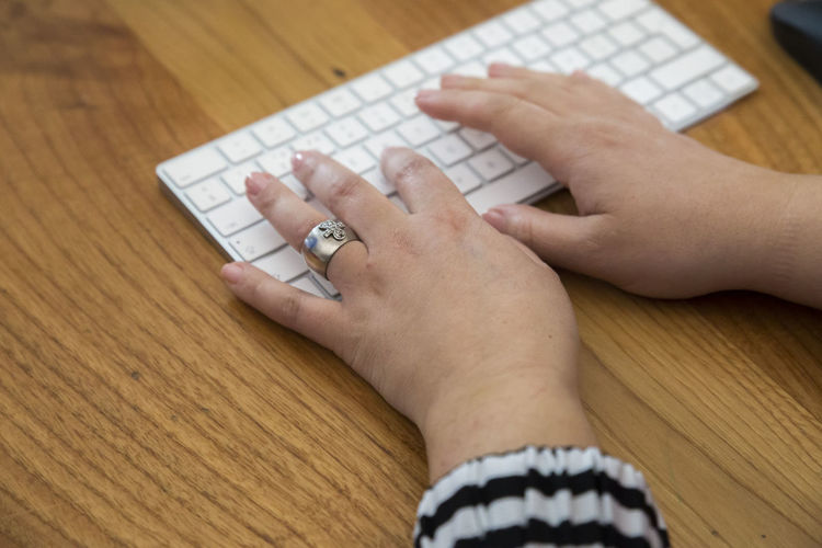 Cropped hands of woman holding jigsaw pieces on table