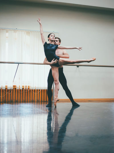 Full length of dancers dancing in ballet studio