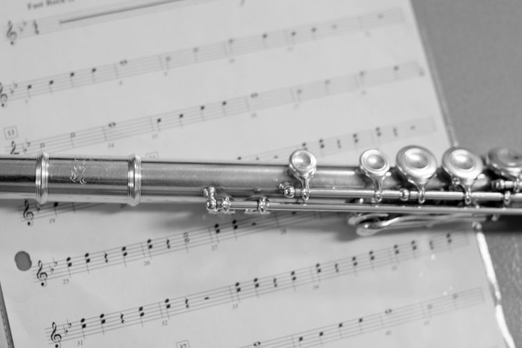 High angle view of musical equipment on sheet music at table