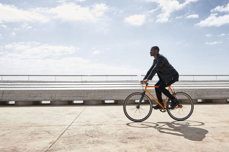 Man riding bike on waterfront promenade