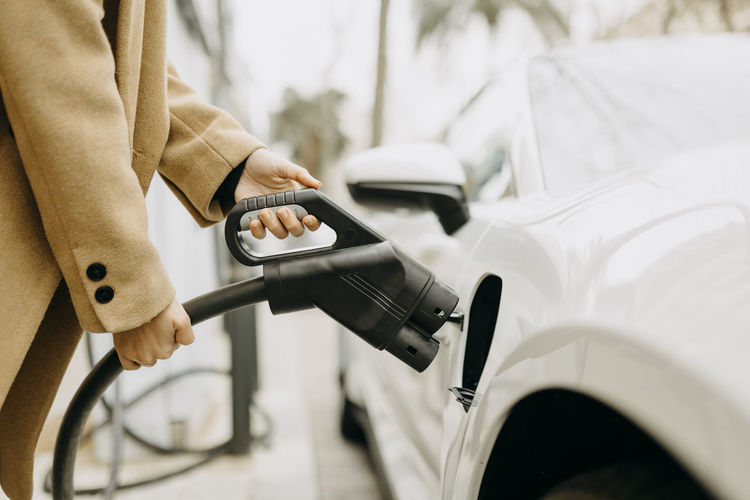 Woman charging electric car at station