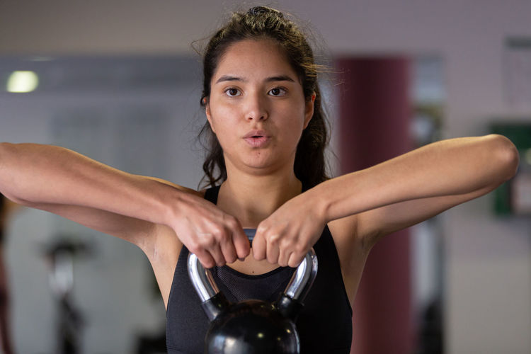 Portrait of young woman exercising at gym