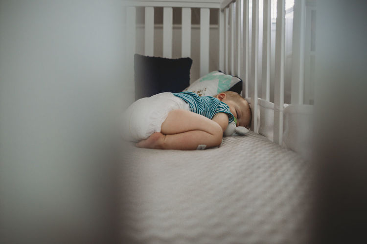 Baby boy sleeping in crib at home