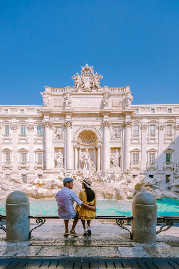 Rear view of couple against historical building