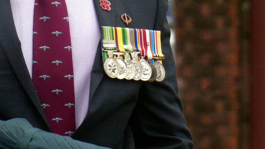 Midsection of man in suit military veteran wearing medals