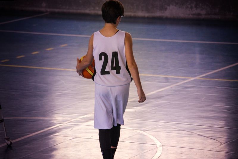 Rear view of boy playing basketball