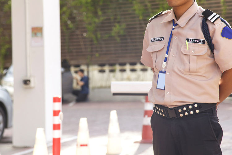 Midsection of male security standing outdoors