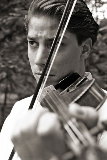 Close-up of man playing violin while standing outdoors